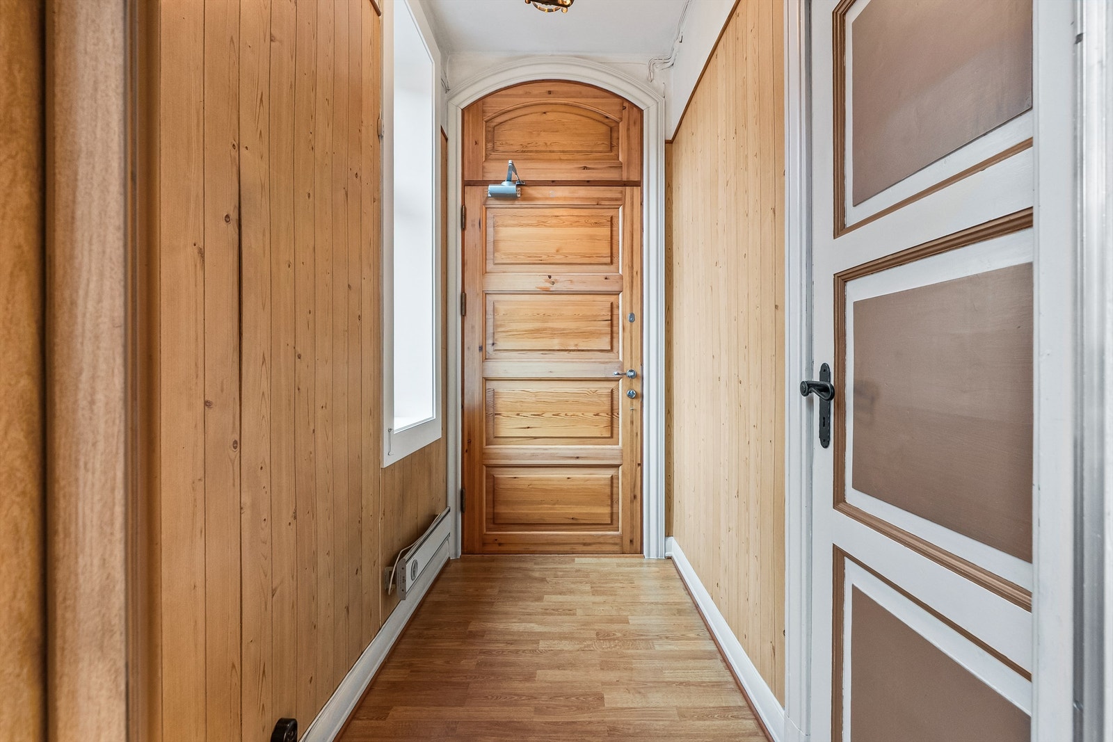 Fra felles trappeoppgang kommer du inn i en entré med panelkledde vegger. Galleribilde