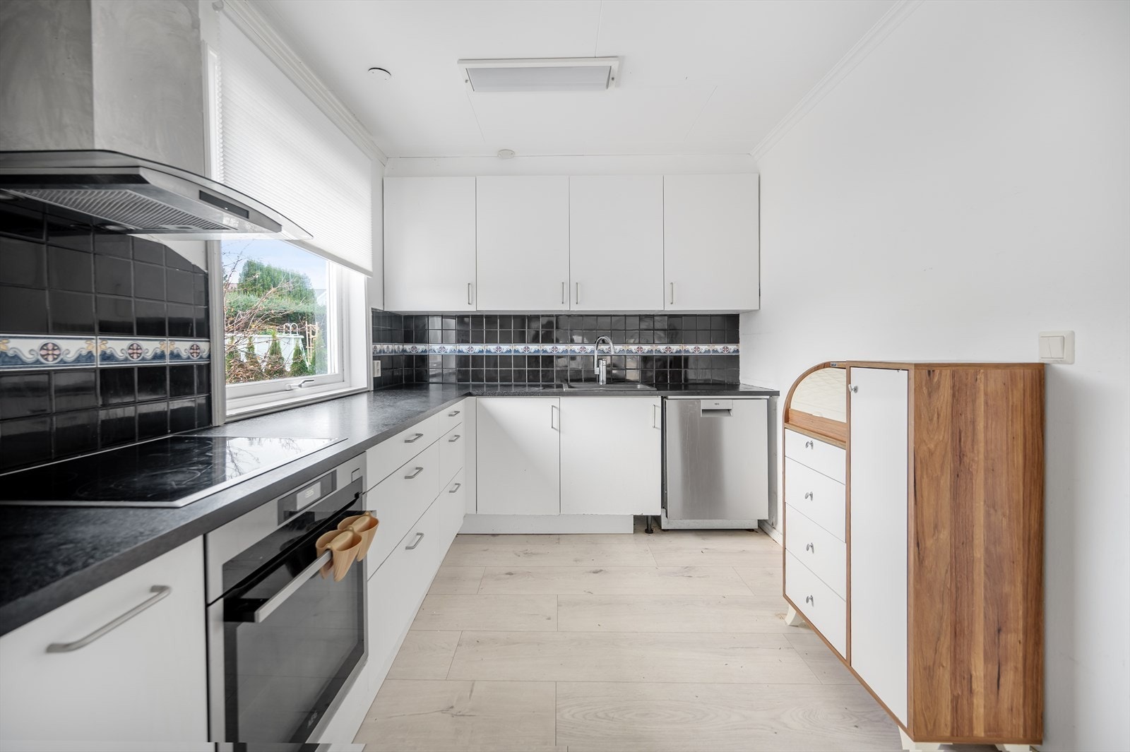 Kjøkkenet ligger i en L-formet løsning med åpen forbindelse mot spisestue og stue, noe som gir en romslig og sosial planløsning. Galleribilde