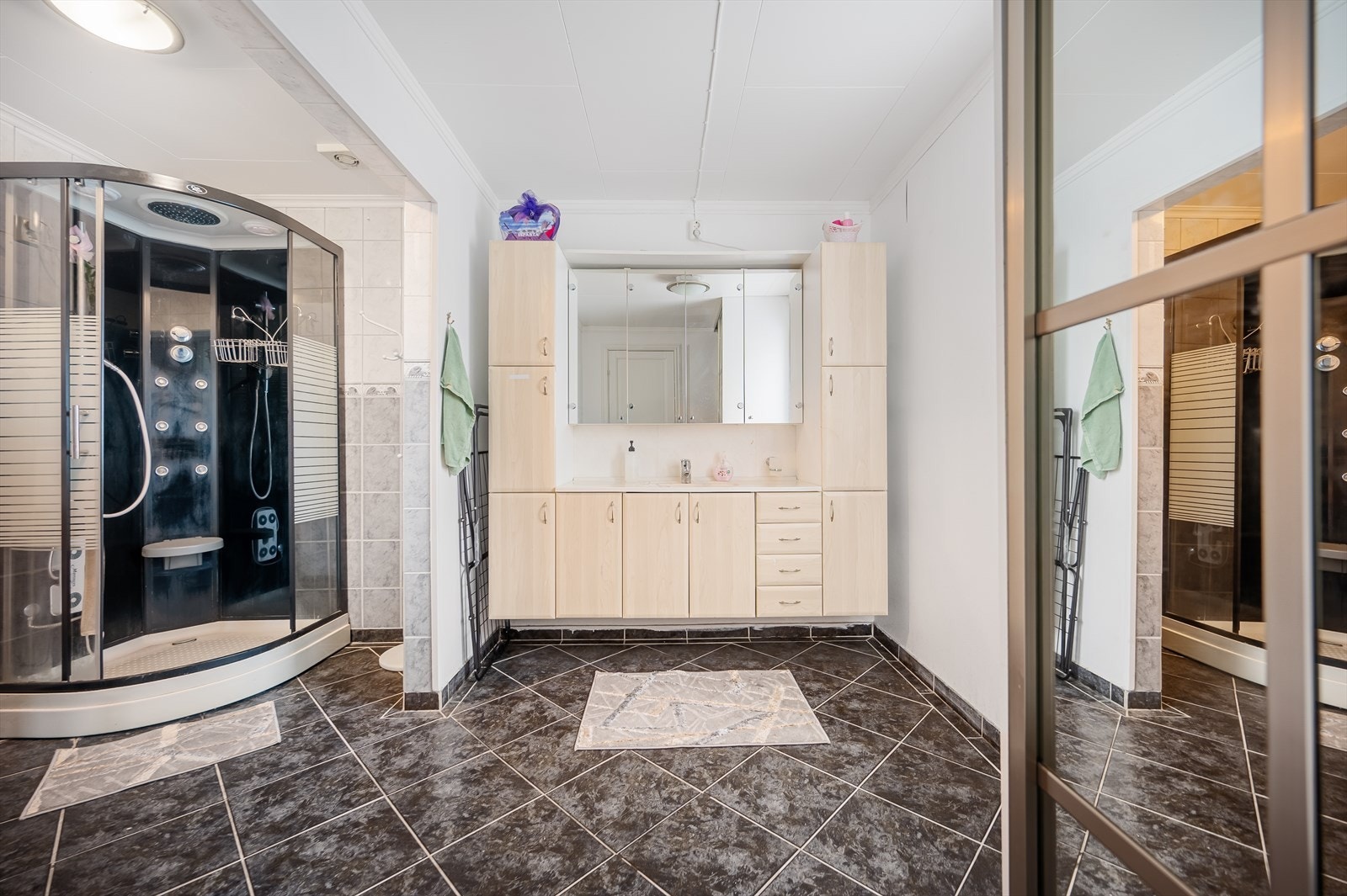 Badet i 1. etasje er av god størrelse og inneholder blant annet servant med innredning, dusjkabinett og vegghengt toalett. Galleribilde