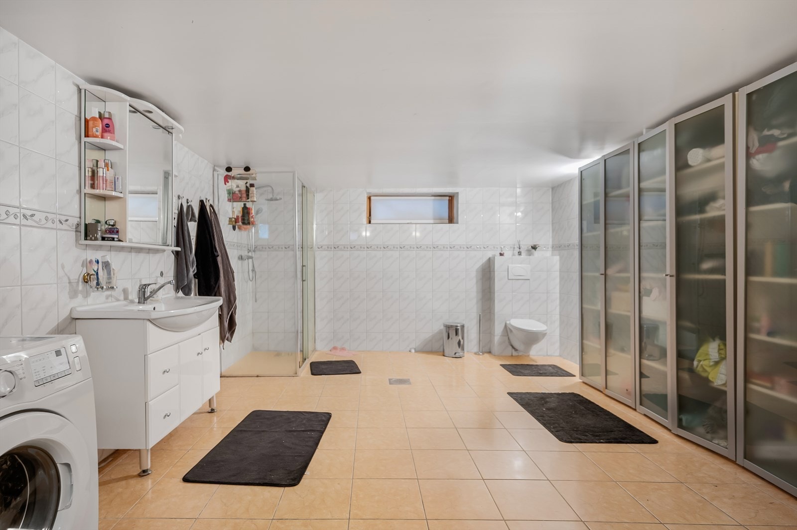 Rommet er utstyrt med nedfelt servant, vegghengt toalett, dusjnisje med glassdør og opplegg for vaskemaskin. Galleribilde