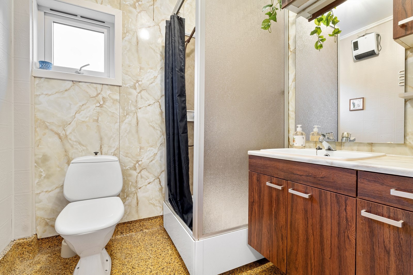 Badet i hovedetasjen er innredet med dusjkabinett, servant med møblement og wc. Galleribilde