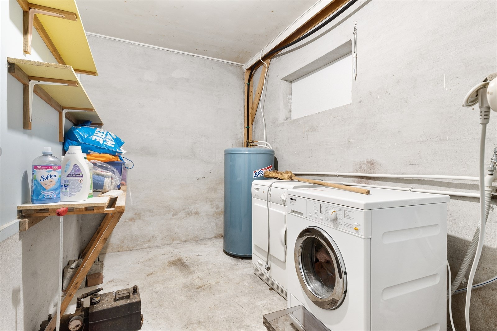 Et praktisk vaskerom med opplegg for vaskemaskin og plassering av varmtvannsbereder. Galleribilde