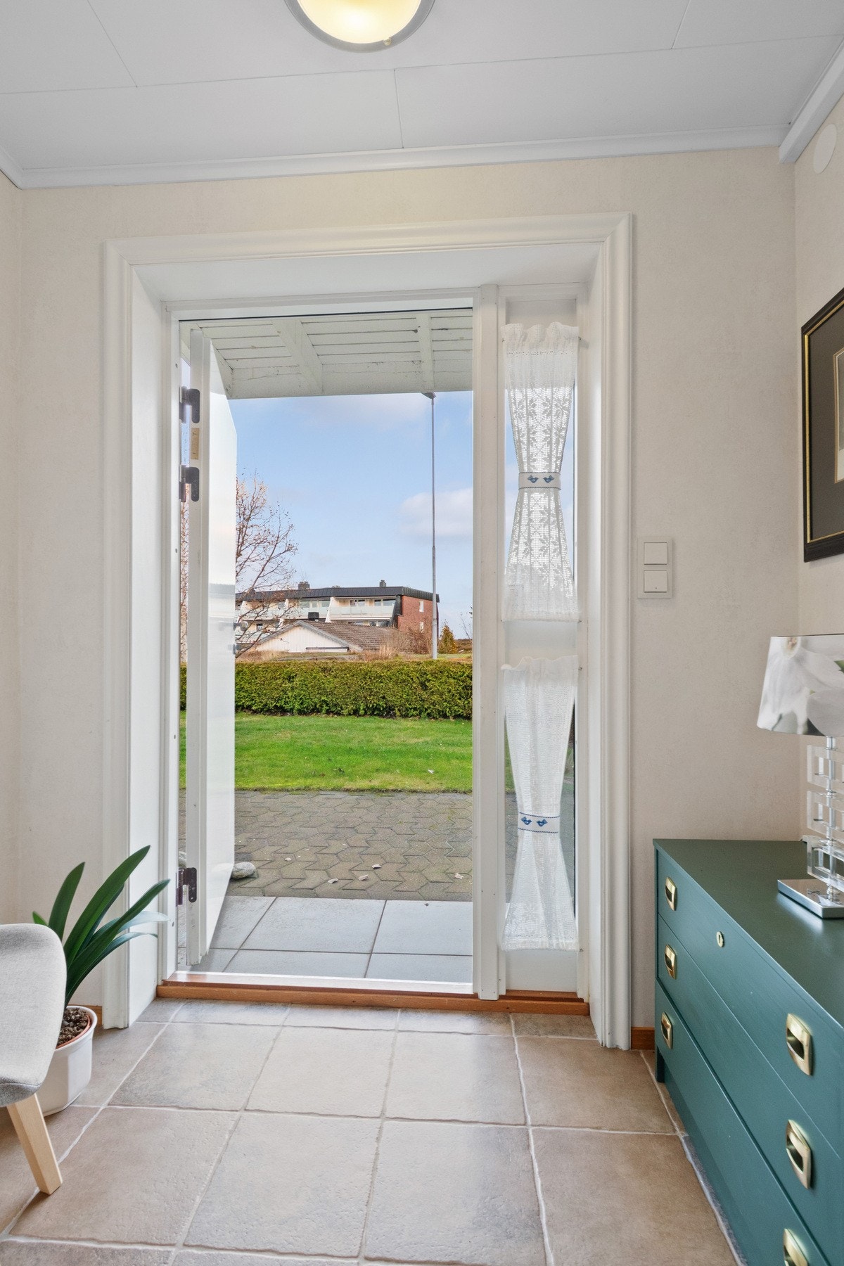 Vel inne blir vi ønsket velkommen i en fin entré med lyse vegger og sandfargede fliser på gulvet. Galleribilde