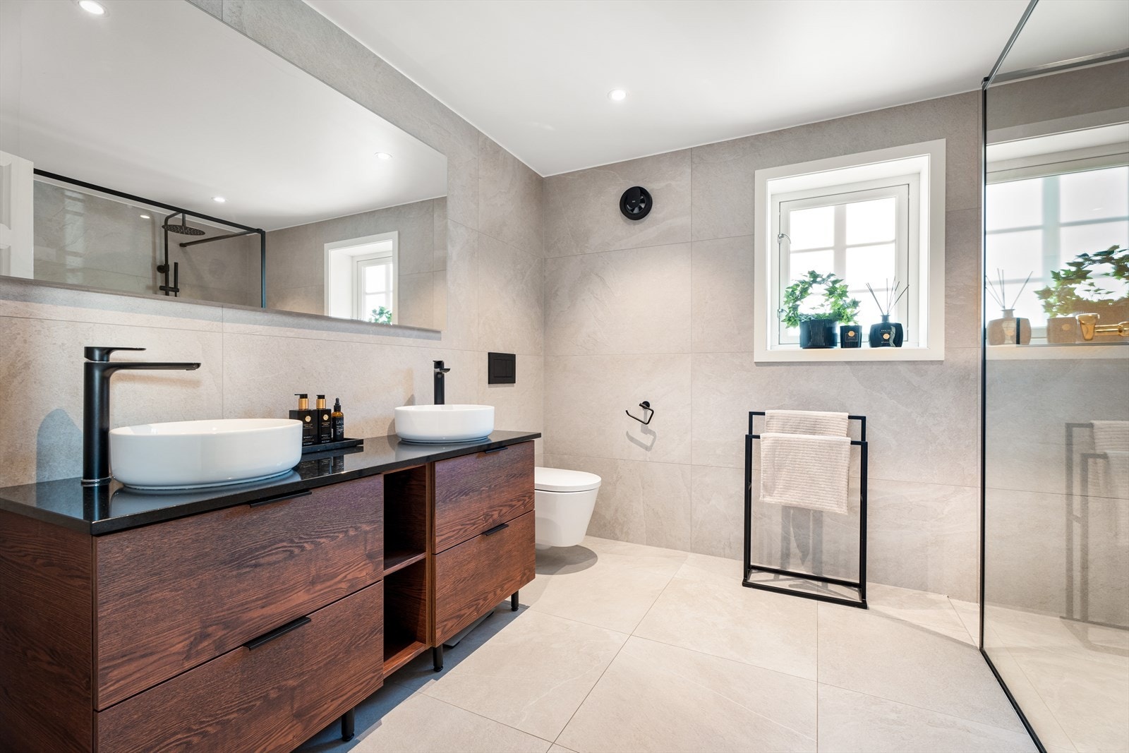 Baderommet har en meget kledelig skuffinnredning med dobbelt sett med servanter samt lyssatt speil over. Galleribilde