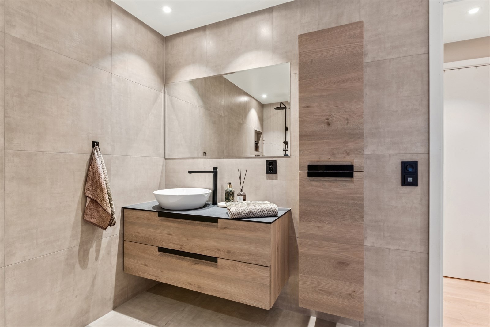 Rommet er utstyrt med en moderne innredning med servant, speil og veggmontert toalett. Galleribilde