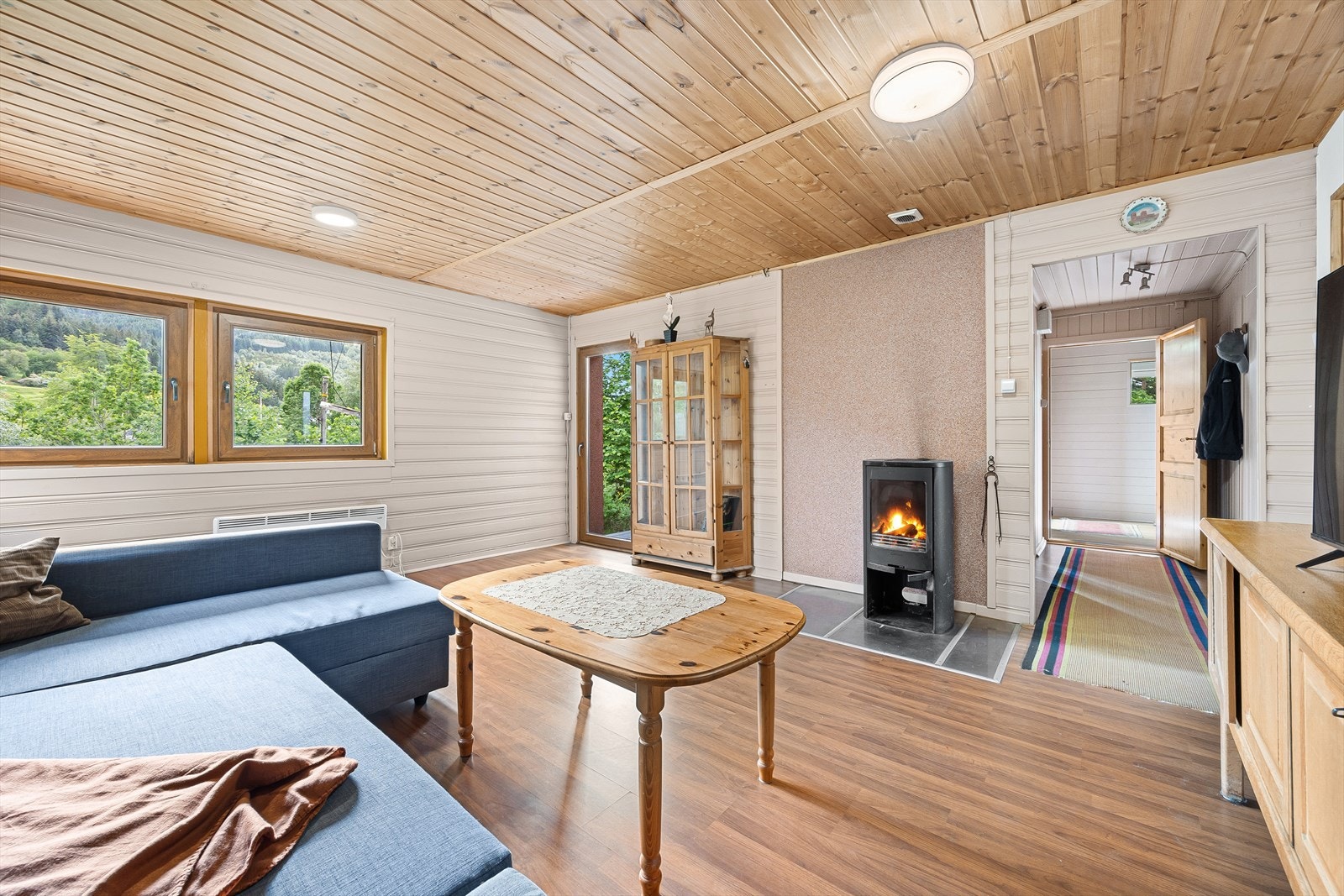 Stue: Rommets vindusflater sørger for godt med naturlig lysinnslipp, samt en naturskjønn utsikt. Fra stuen er det også utgang til terrasse, hvor du kan nyte solen hele dagen på sommerstid. Galleribilde