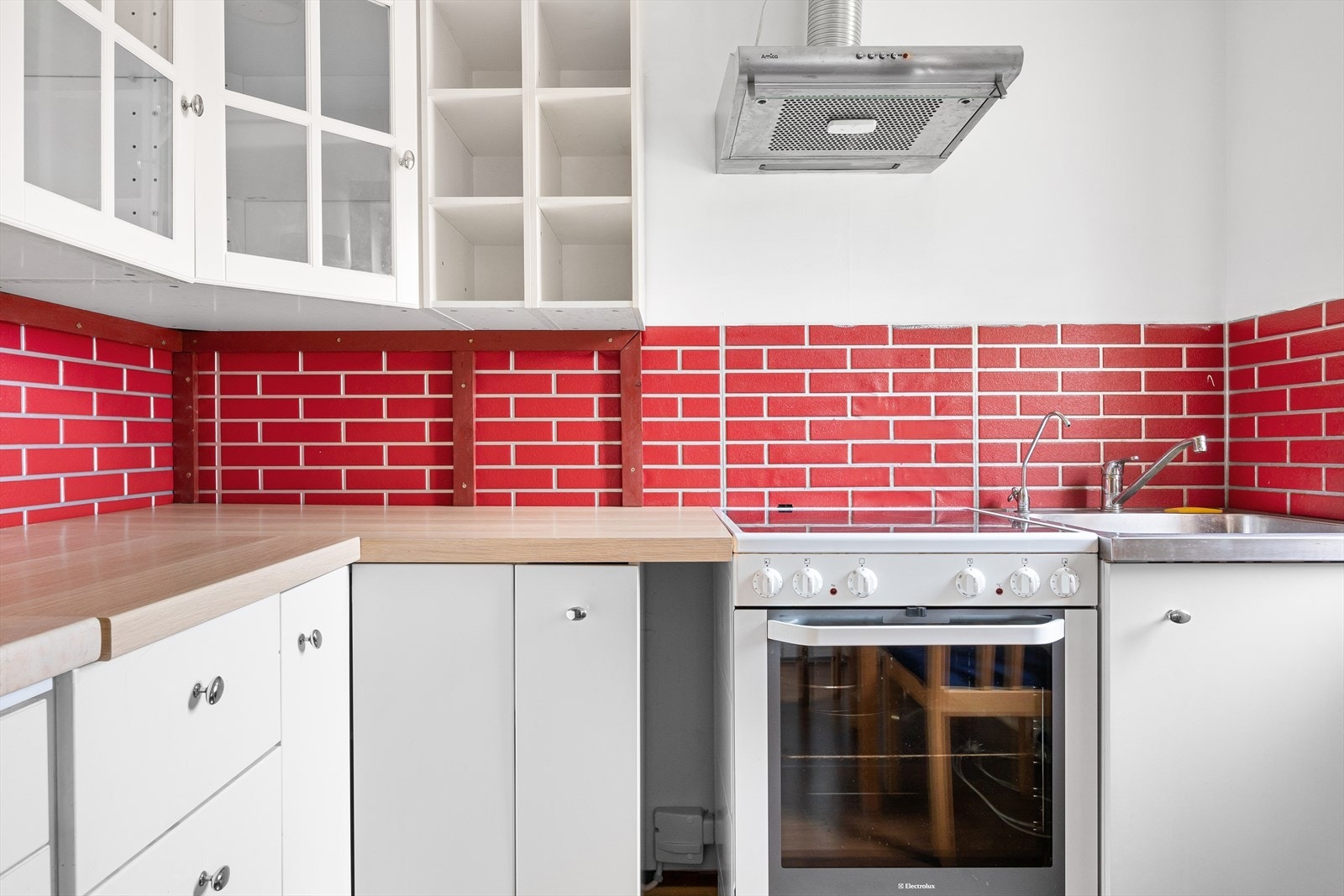 Kjøkkenet har glatte fronter og benkeplate med nedfelt vask, med opplegg for komfyr og kjøleskap/frys. Galleribilde