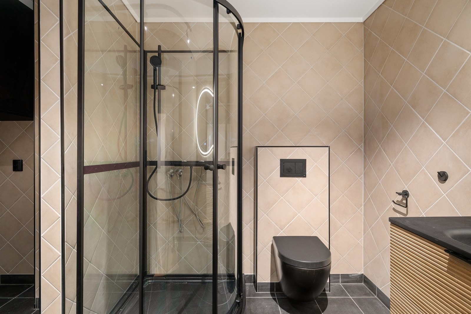 Baderommet fremstår stilrent og innbydende, med fliser på både gulv og vegger, samt slett himling som gir et rent og moderne uttrykk. Galleribilde