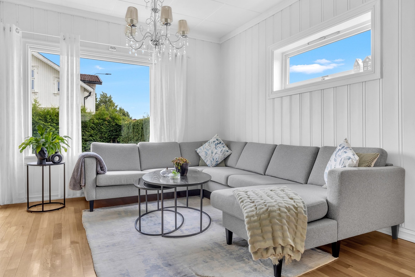 Hjørneløsning i stuen gir en naturlig sone for avslapning, med utsyn til både hage og nabolag. Galleribilde