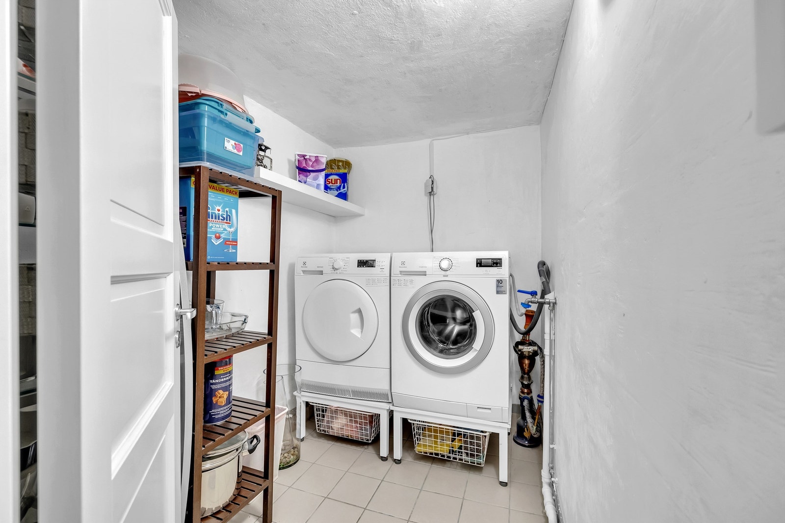 Praktisk vaskerom i kjelleren fra 2010 med flislagt gulv, opplegg for vaskemaskin og tørketrommel. Galleribilde