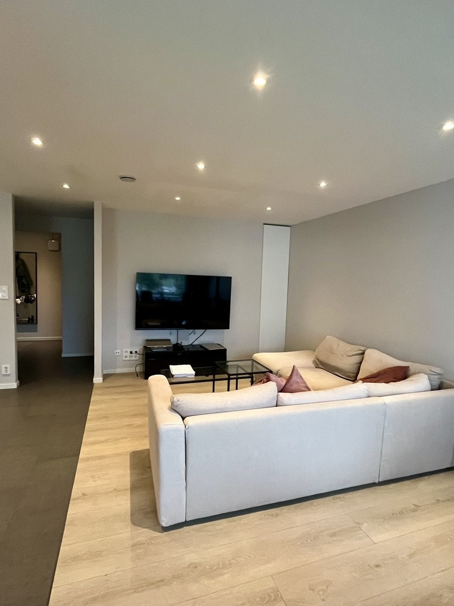 Stue med sofa og stor TV Galleribilde