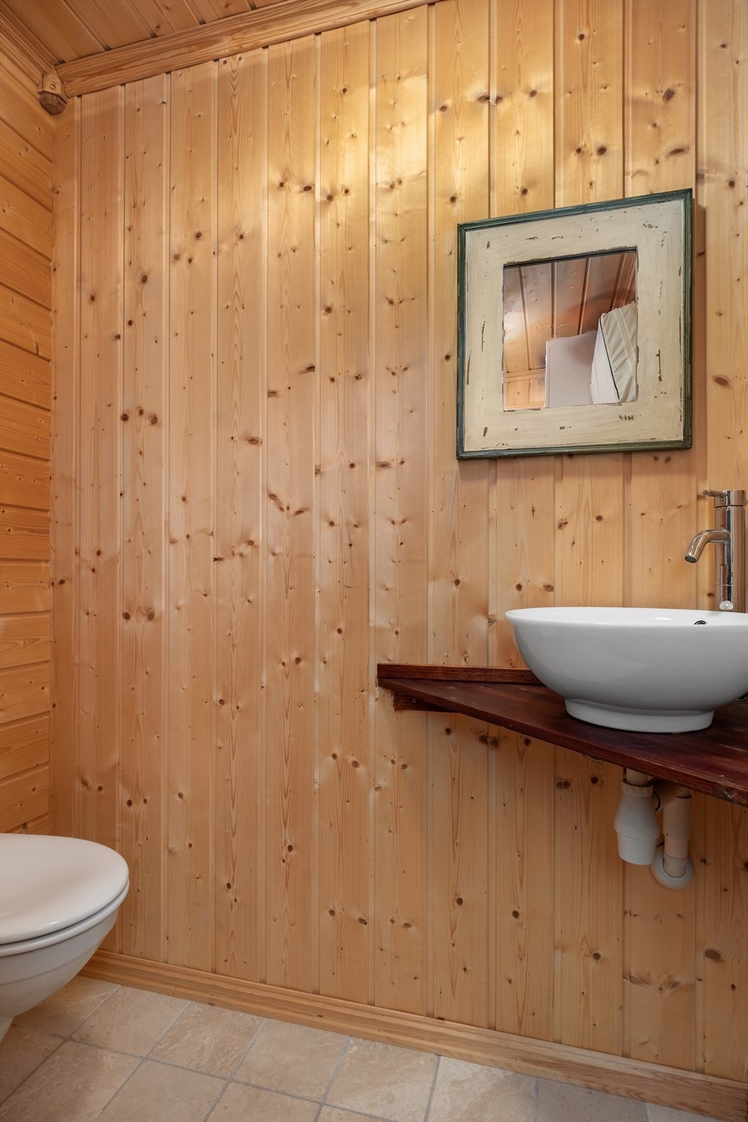 Toalettrom med flisar på golv og panel på vegg og i himling. Galleribilde