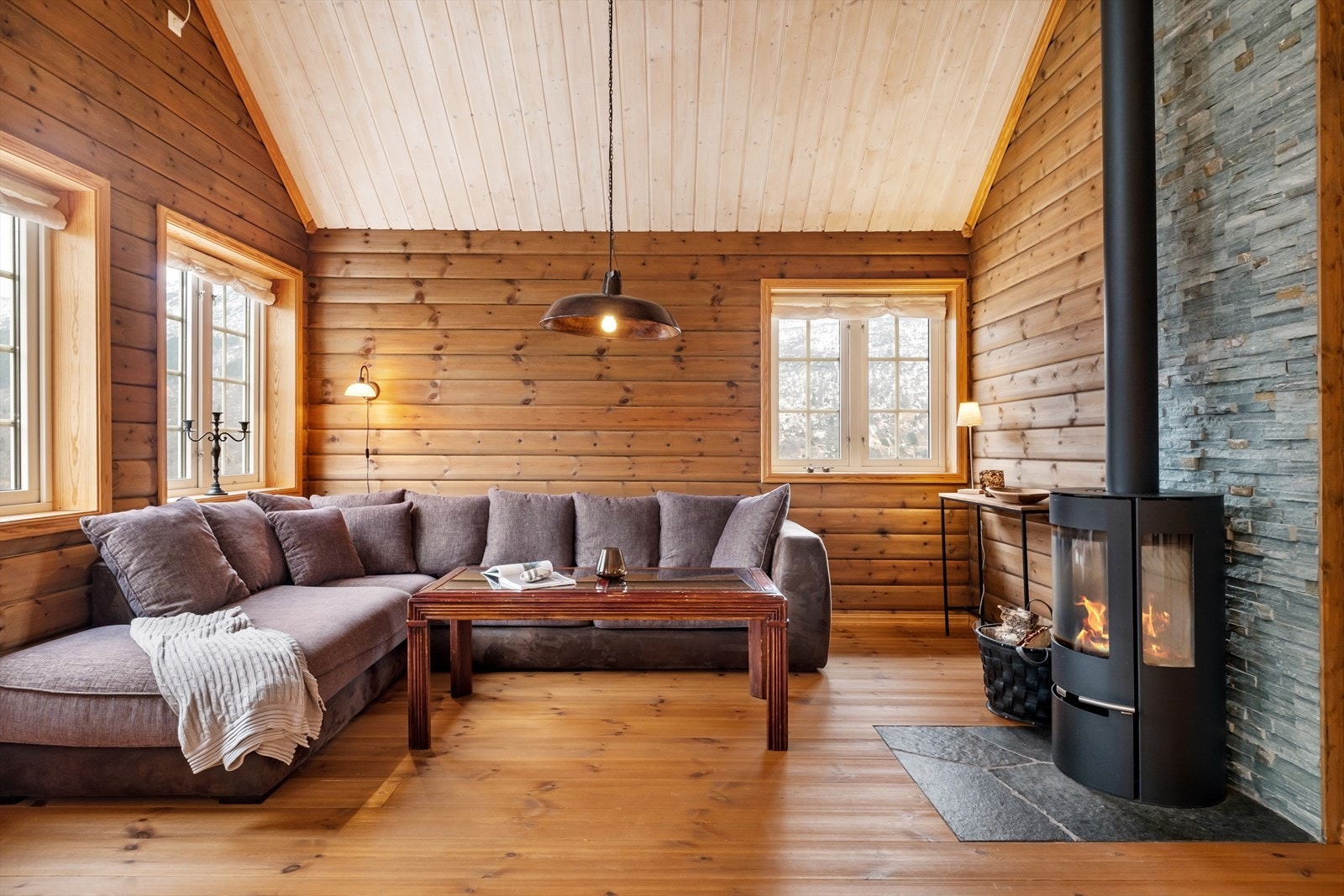 Stova er lun og triveleg med plass til romsleg sittegruppe. Her er innreia med ein dekorativ vedomn som gir god varme på kalde dagar. Galleribilde
