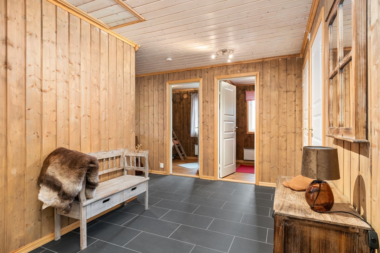 Entréen har flislagt golv og panel på veggar. Frå entréen er det tilkomst videre inn til resten av hytta. Galleribilde