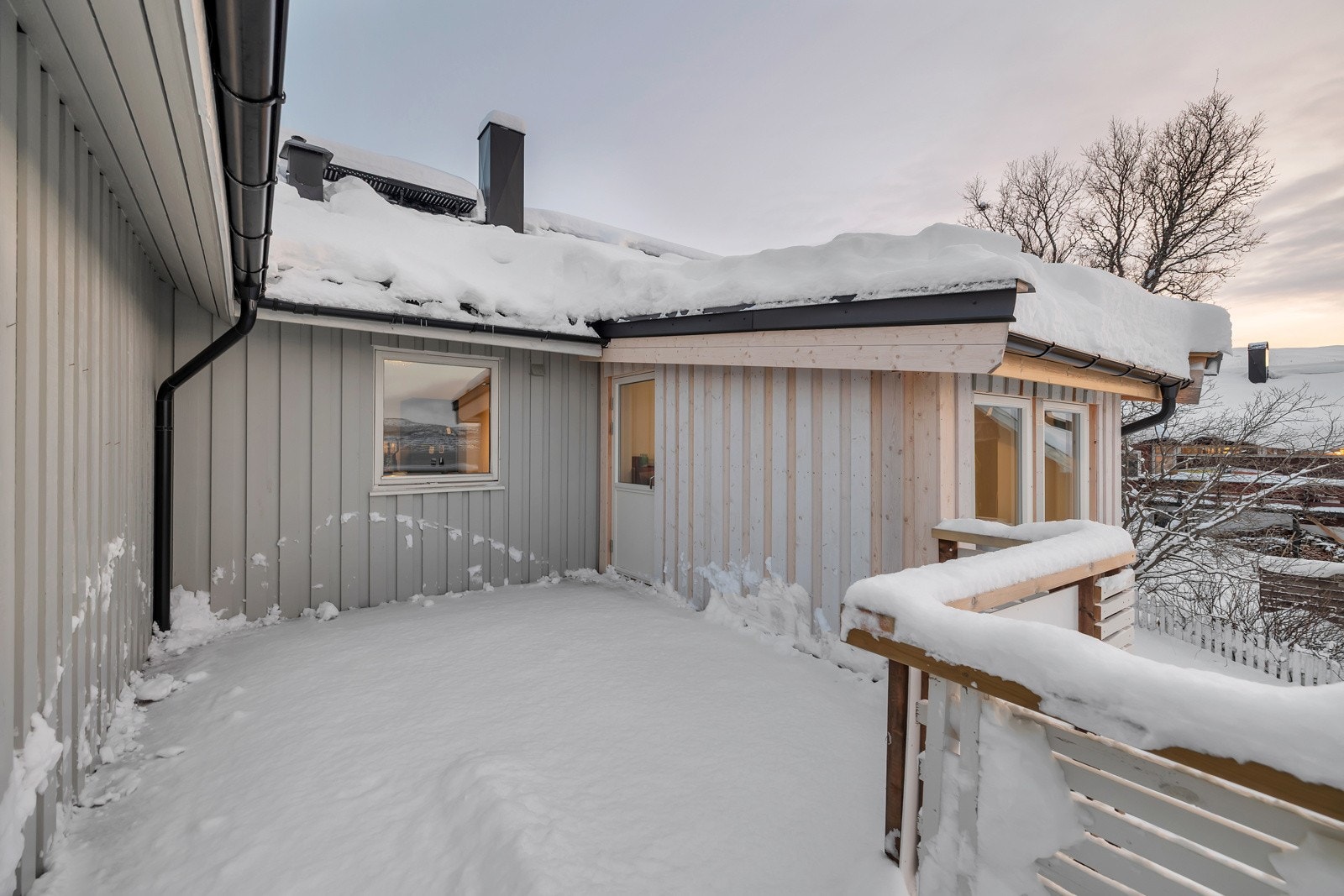 Verandaen strekker seg rundt sørsiden av boligen Galleribilde