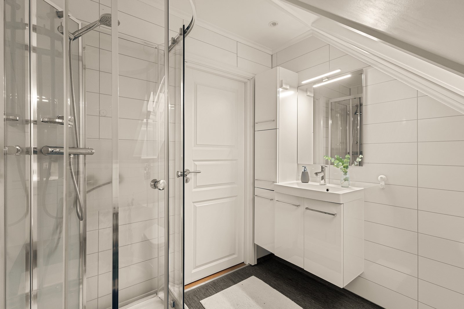 Det er innredet med dusjkabinett, servant med underskap og sideskap, samt vegghengt toalett. Galleribilde