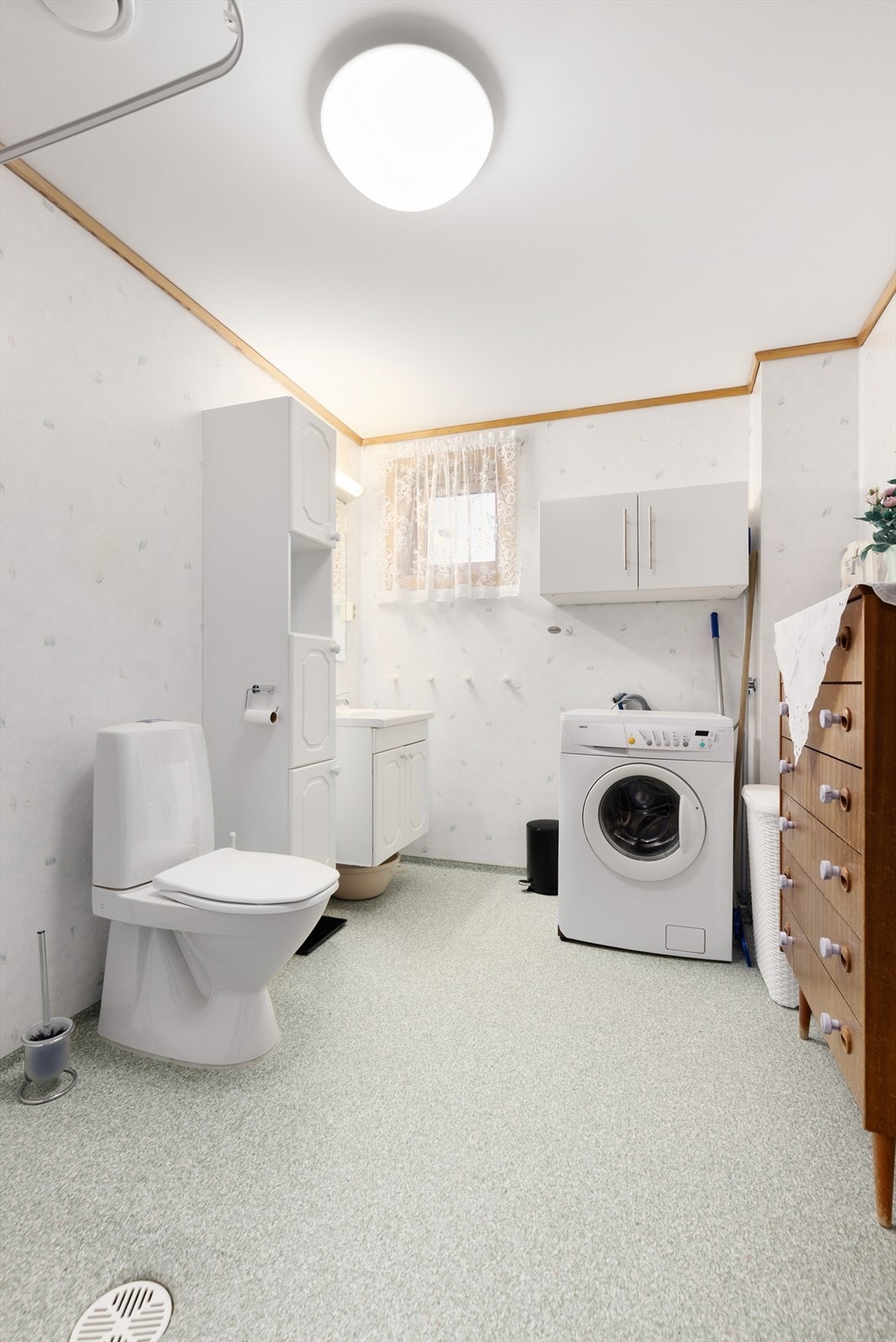 Badet inneholder gulvmontert toalett, dusjnisje med forheng og opplegg til vaskemaskin. Videre inneholder badet heldekkende servant med underskap, speil, lys, høyskap samt skap montert på vegg. Galleribilde