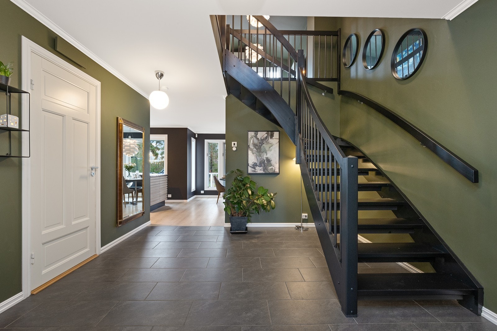 Fra den romslige gangen leder en solid, malt tretrapp opp til andre etasje Galleribilde