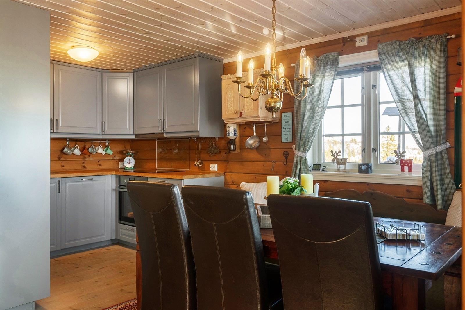 Kjøkkenet har innredning i malte folierte plater med over- og underskap, hjørnekarusell, heltre benkeplate i eik og oppvaskkum med kran av stål. Galleribilde