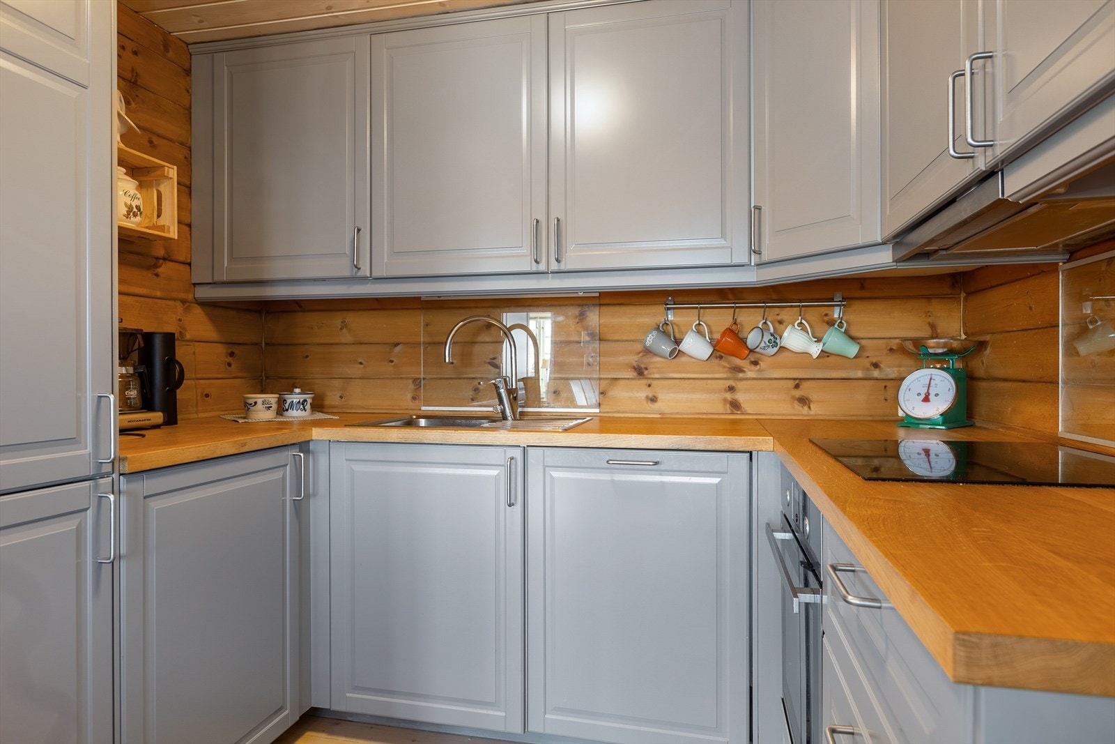 Det er glassplate på vegg ved koketopp og oppvaskkum. Her er også montert komfyrvakt og vannstoppeføler. Galleribilde