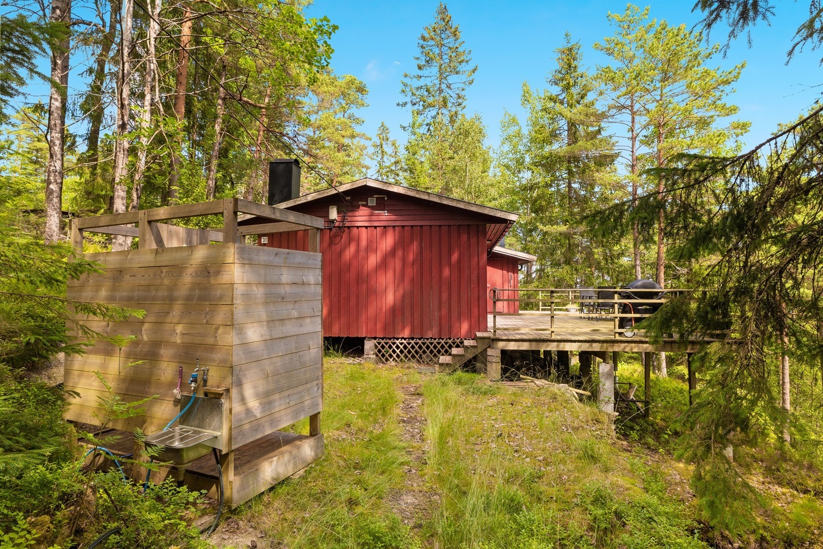 Fra terrassen er det satt opp en enkel utedusj og utslagsvask. Galleribilde