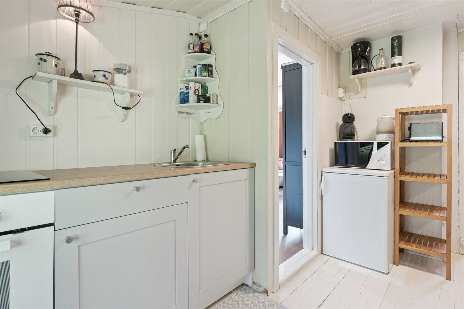 Samtidig fikk rommet en ny benk med nedfelt oppvaskkum, integrert koketopp og stekeovn. Frittstående mikroovn og kjøleskap. Galleribilde