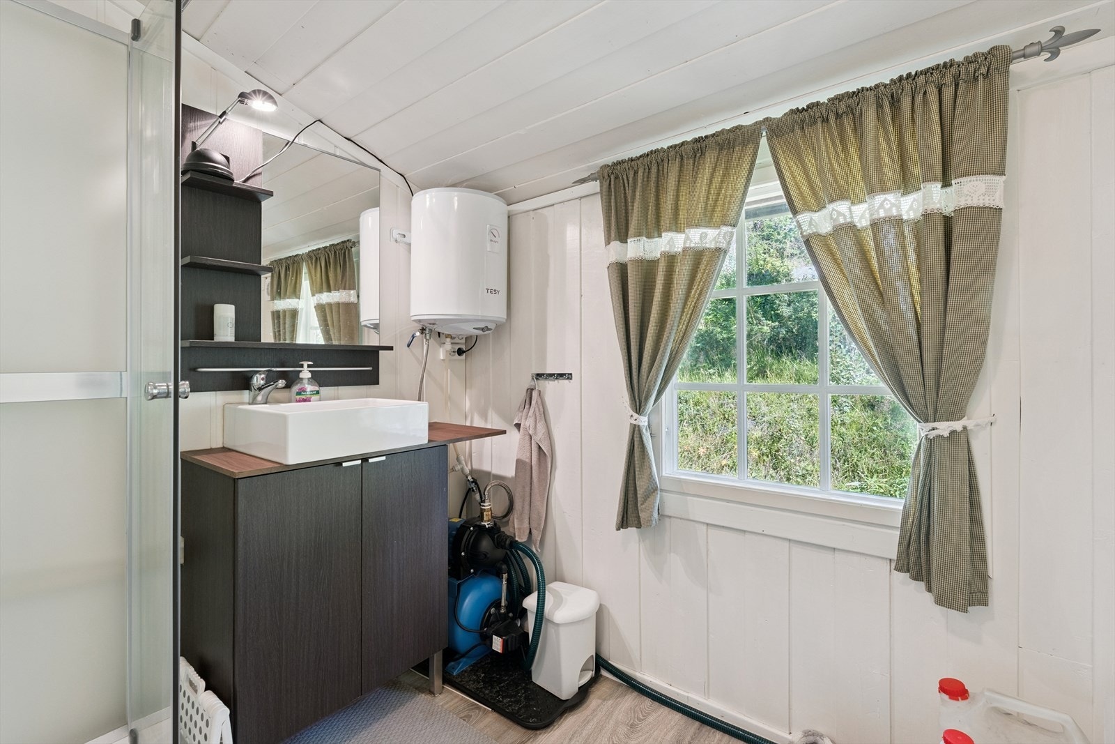 "Hyttebad" uten innlagt vann, med tank som fylles med vann fra kanne. Denne er koblet til vannpumpe og varmtvannsbereder, slik at du får varmt og kaldt vann i servant og dusjkabinett. Galleribilde