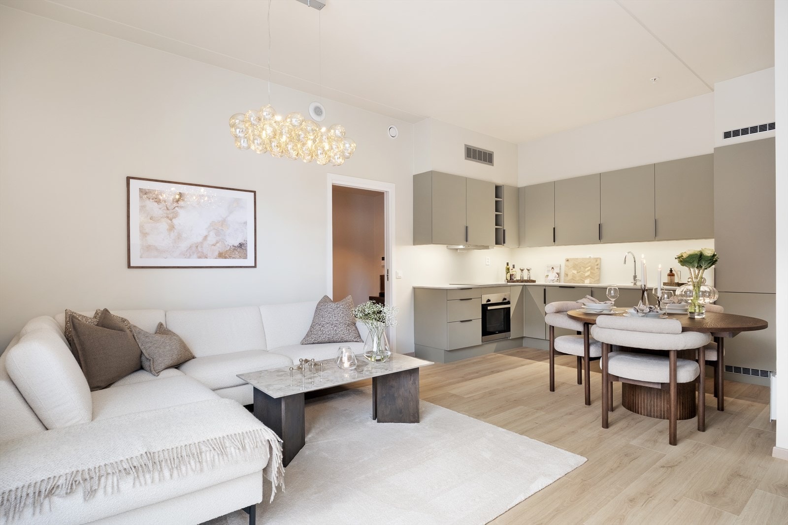 Stove og kjøken i open løysing med rom for ei sofagruppe og spisebord. Galleribilde