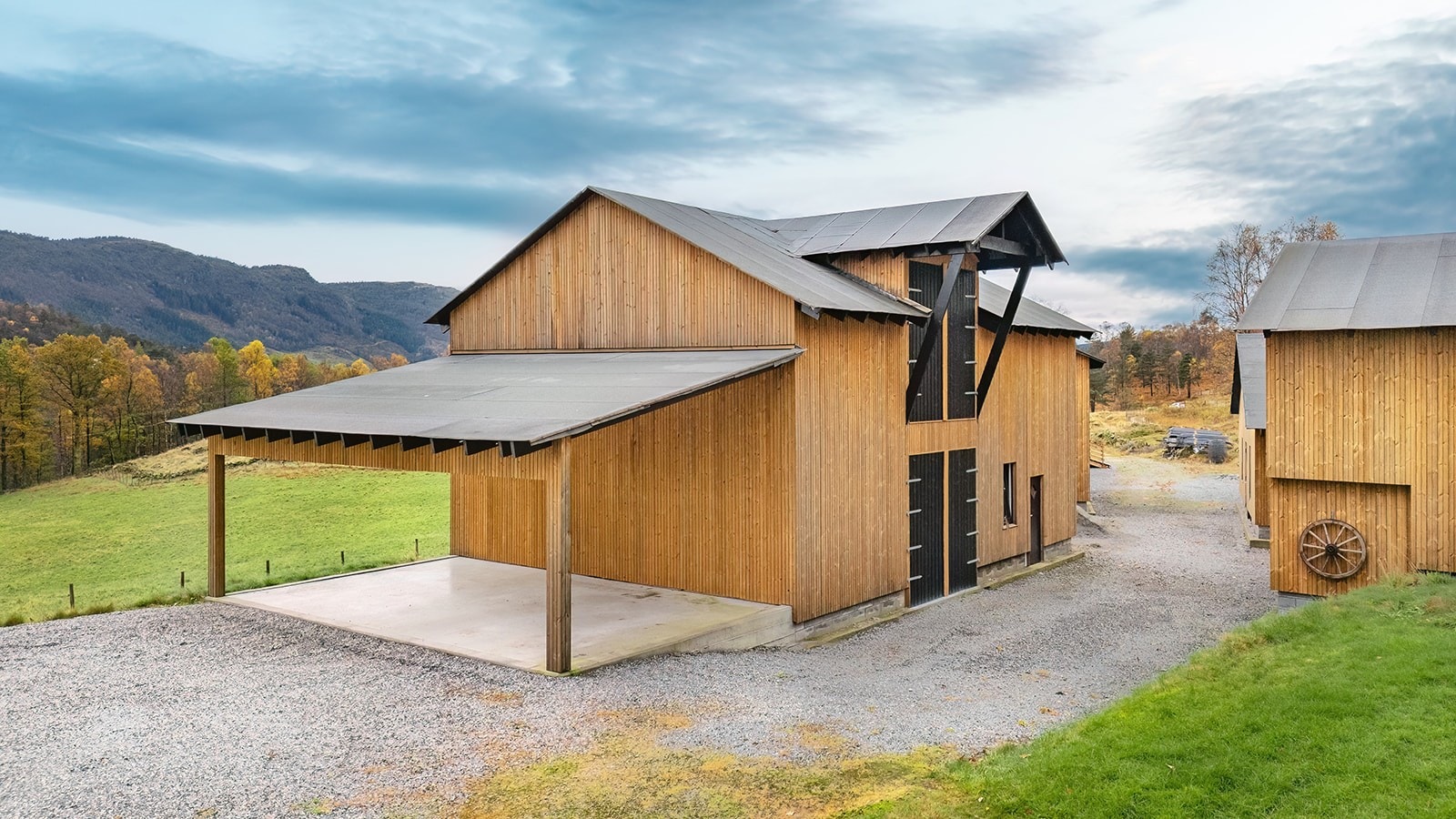 Redskapshus med carport - funksjonelt bygg med takutspring og praktisk heis, som gjør det enkelt å frakte større gjenstander til andre etasje eller laste utstyr. Galleribilde