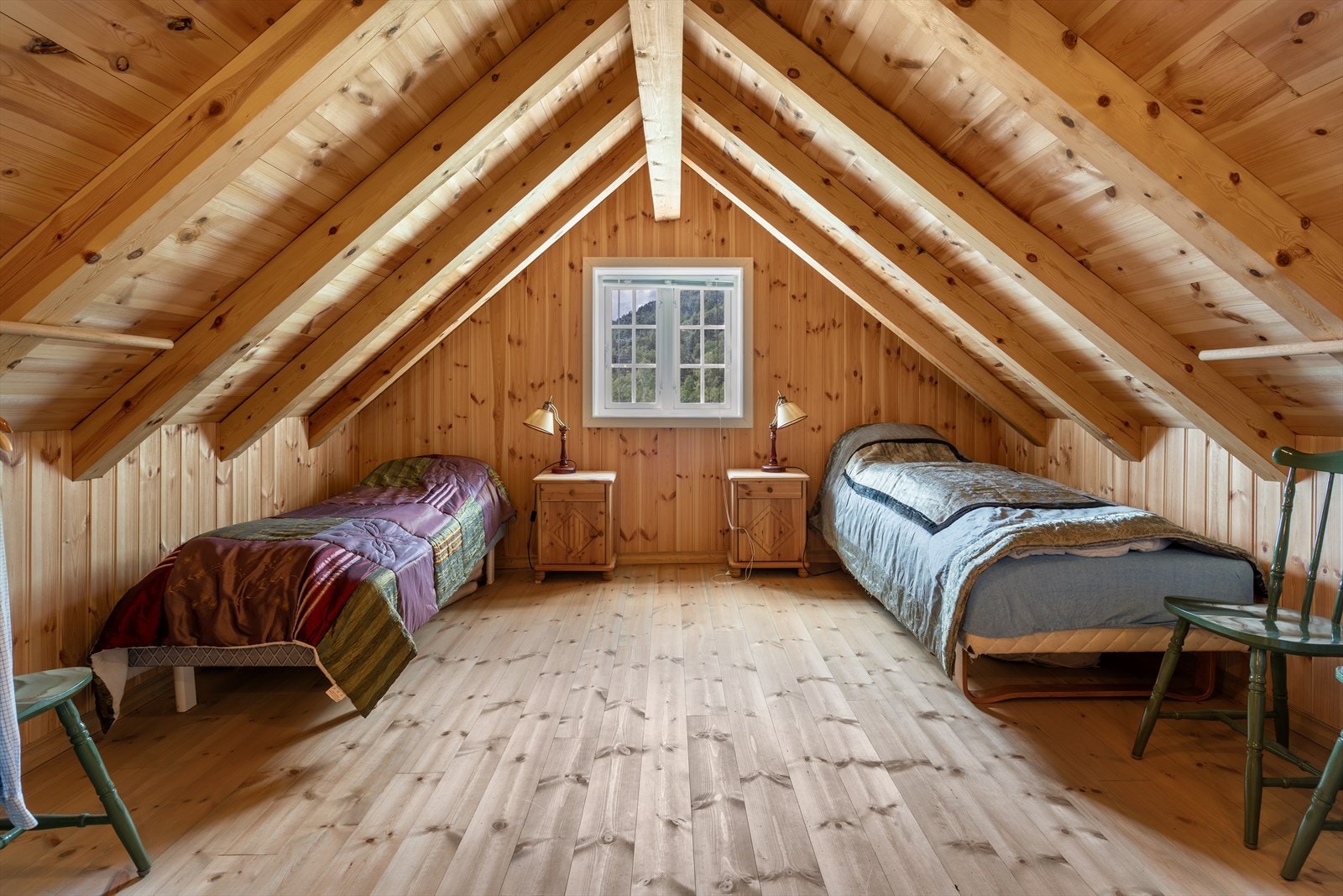 Soverom med synlige takbjelker, skråtak og furupanel som gir rommet koselig preg. Galleribilde