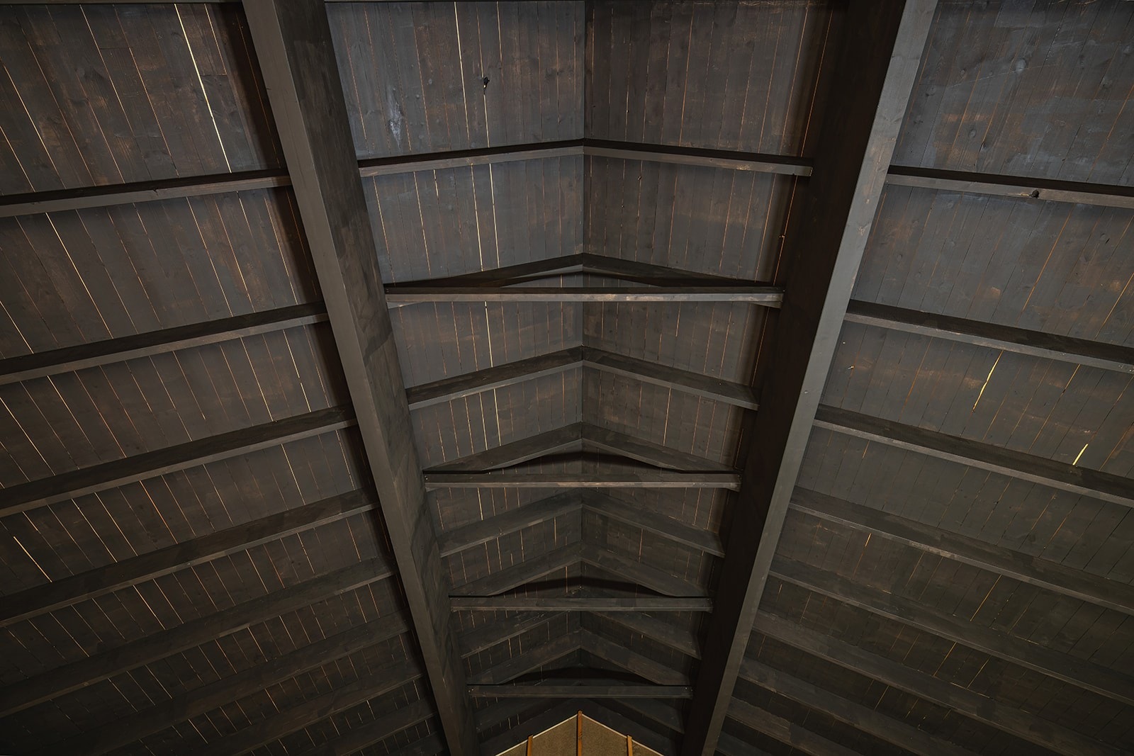 Eldhuset har et vakkert tak med synlige bjelker, malt i en lekker mørk beis, som fremhever byggets tradisjonelle sjarm og autentiske karakter. Galleribilde