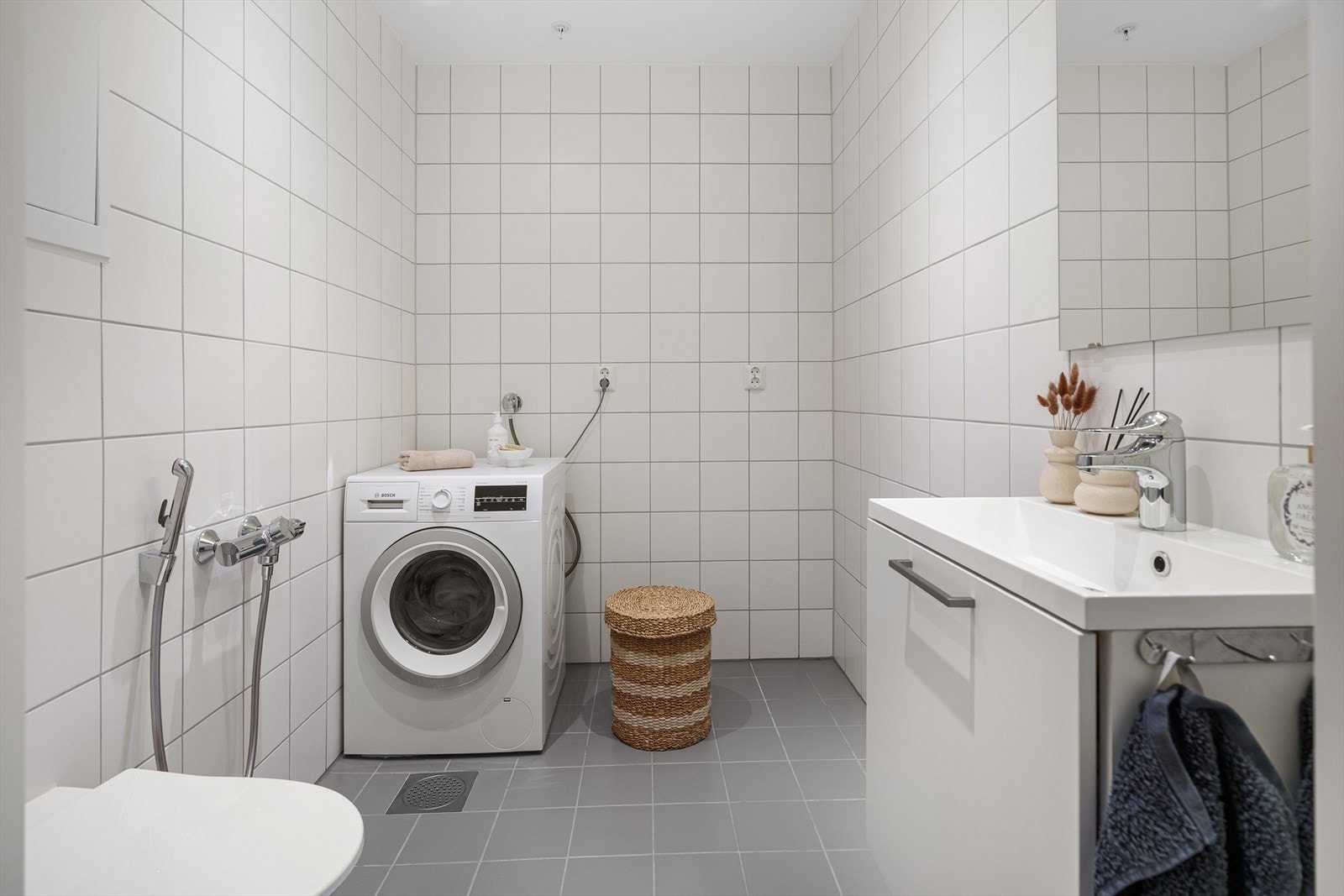 - Baderom med vegghengt toalett, servant og opplegg for vaskemaskin - Galleribilde