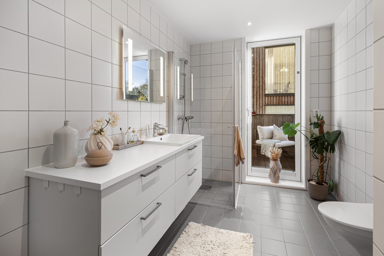 - Nydelig fliselagt bad med vannbåren varme, dusjhjørne, veggheng toalett, servant med underskap og speil med belysning - Galleribilde