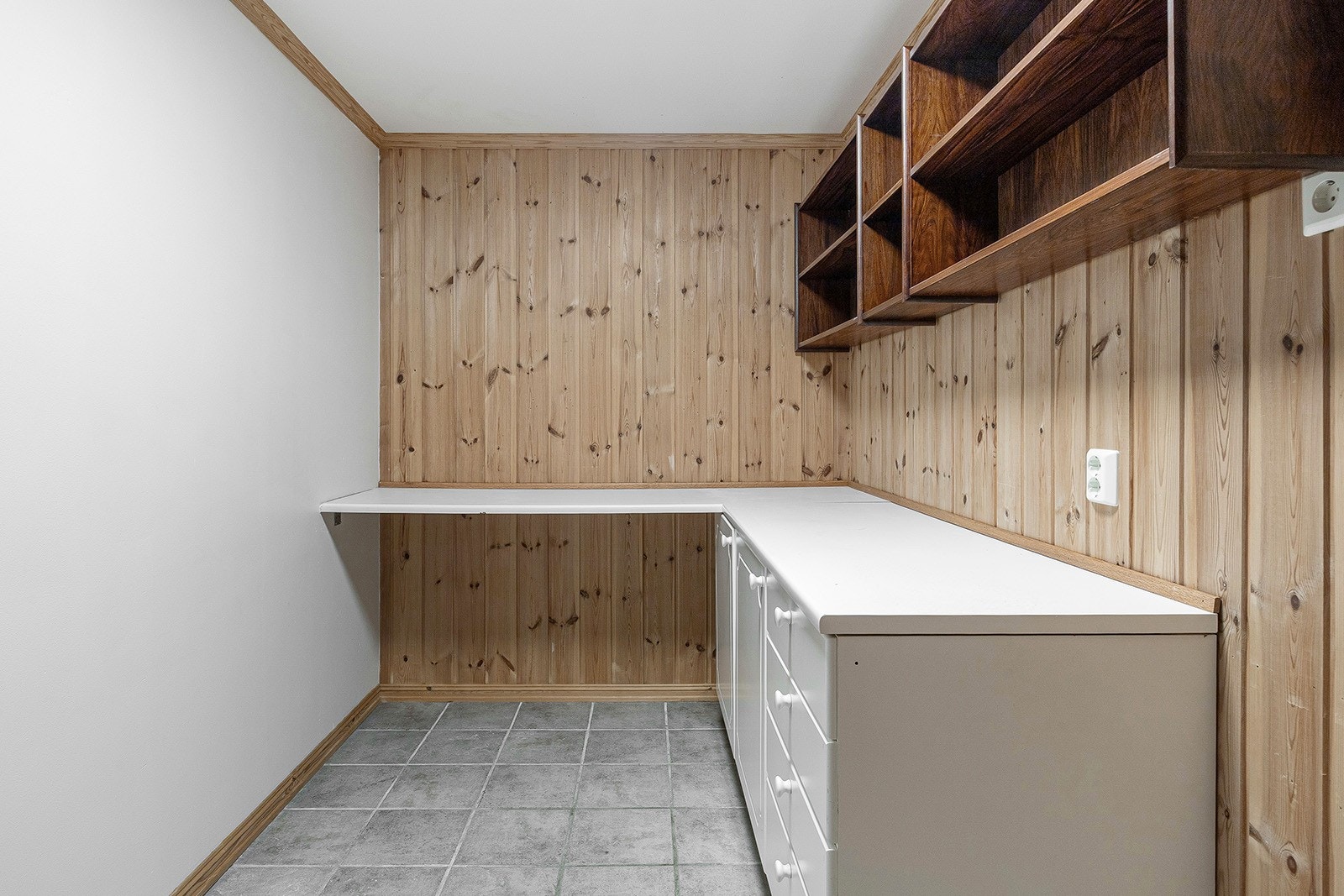 Romslig vaskerom med fliser på gulv, god skapplass og en praktisk benkeplate. Her er det opplegg for vaskemaskin, tørketrommel og en praktisk utslagsvask, Galleribilde