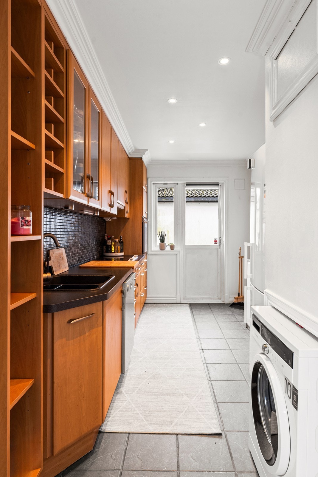 Kjøkkenet ligger separat, og har de samme lyse overflatene som i stuen. Gulvet er praktisk flislagt. I fra kjøkkenet er også utgang til veranda Galleribilde