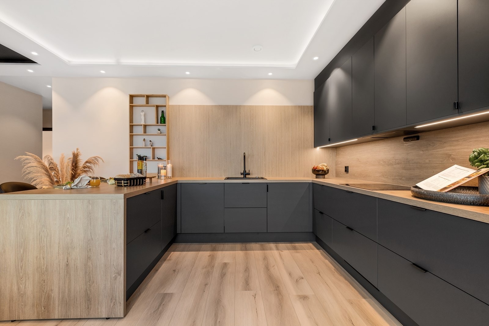 Stilren kjøkkeninnredning fra Epoq i grå utførelse med laminat benkeplate og matchende laminat veggplate med benkebelysning. Nedfelt vask i komposittmateriale. Sort blandebatteri Galleribilde