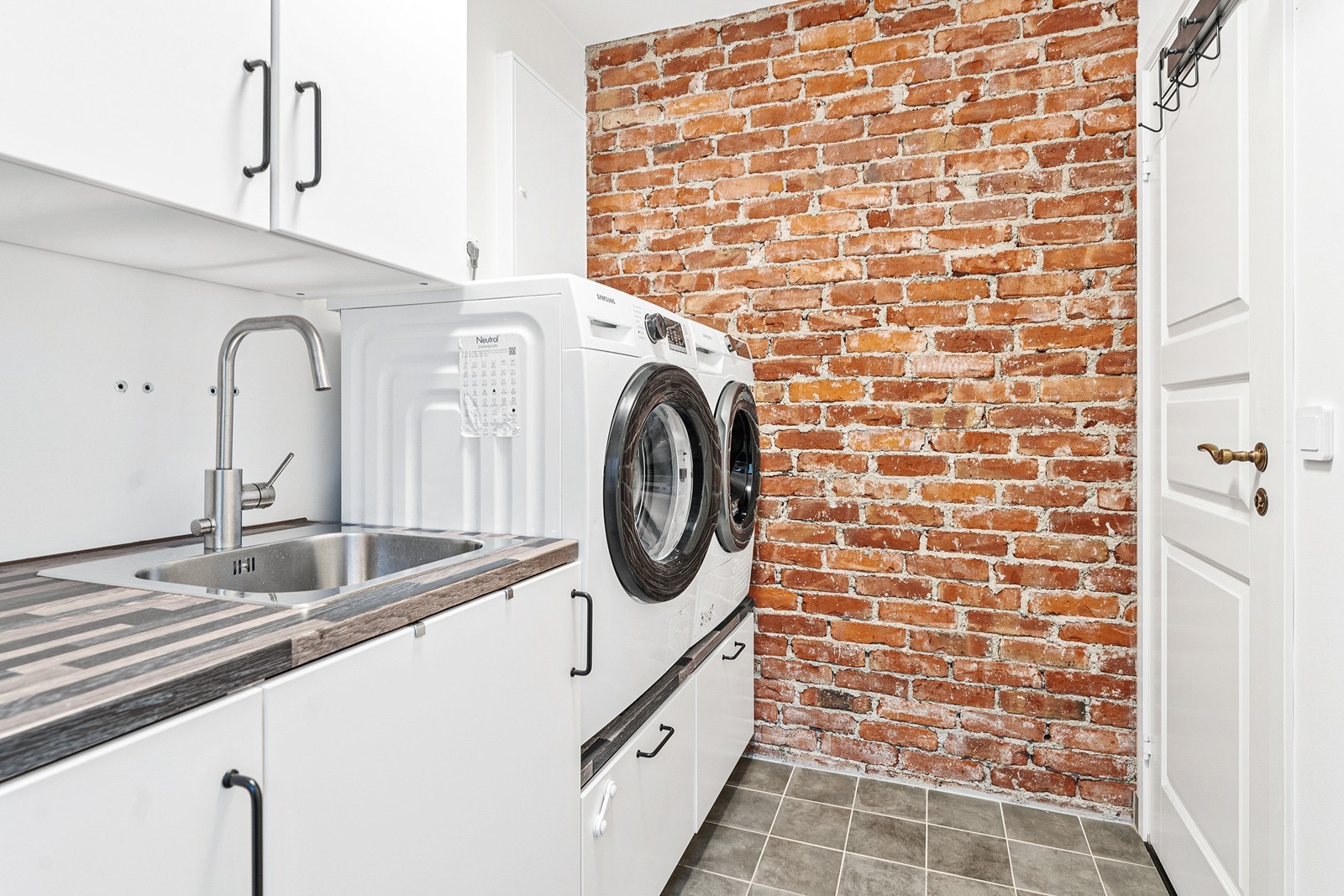 Rommet er utstyrt med innredning med nedfelt vask, ettgreps blandebatteri og opplegg for vaskemaskin. Galleribilde