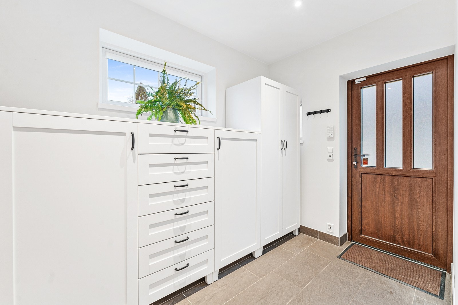 Romslig entré med god oppbevaringsplass. Fliser med varmekabler. Galleribilde