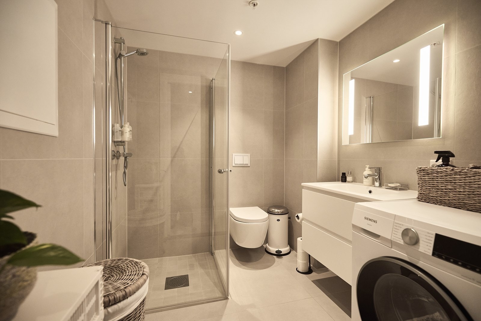 Badet er flislagt med elektriske varmekabler. Det er innredet med servant med underskap, toalett, dusjhjørne og opplegg for vaskemaskin. Galleribilde