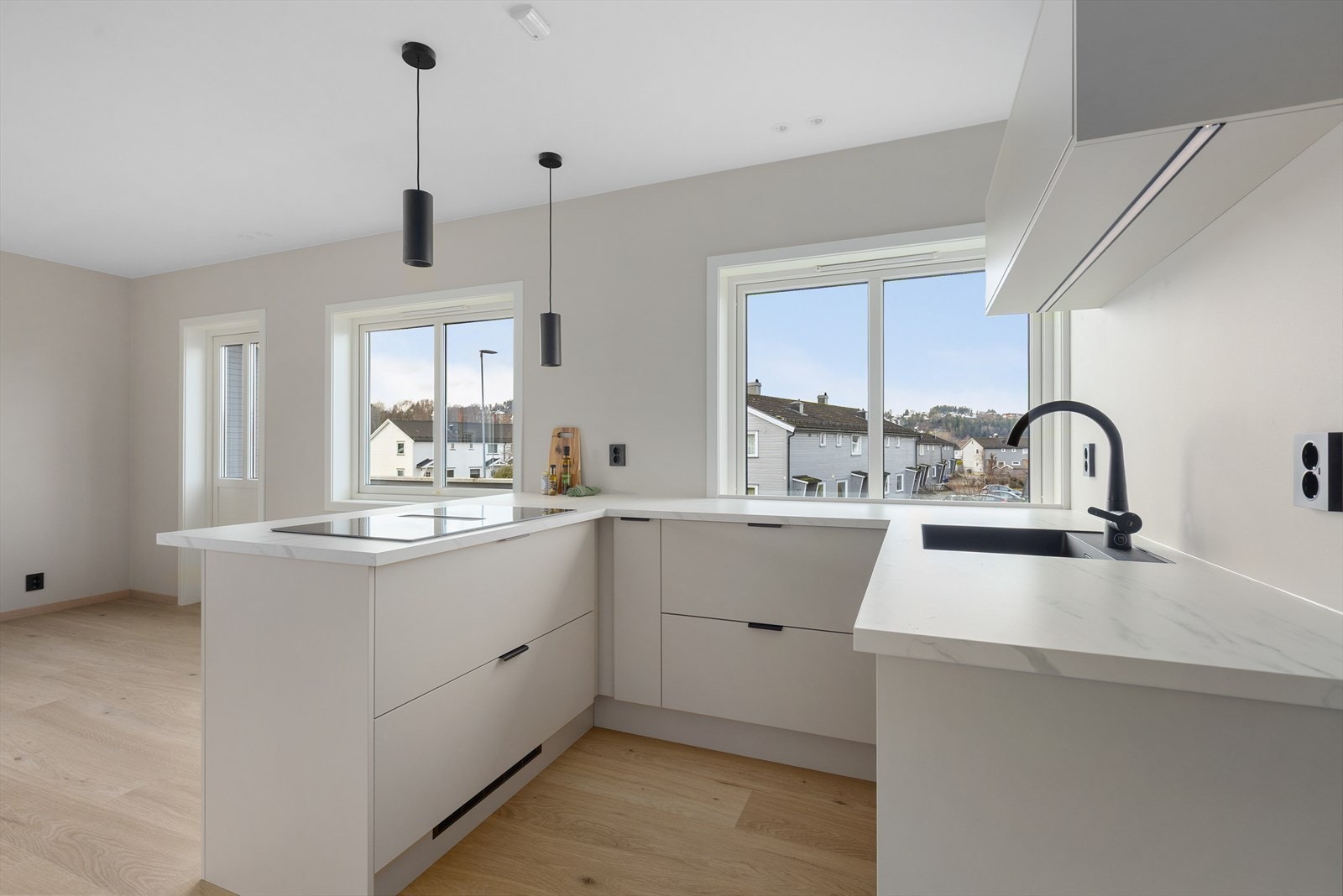 Kjøkkendelen har en stilren og delikat innredning fra Systemkjøkken fra 2025 med slette fronter og laminat benkeplate. Mot stuen er det en halvøy med spiseplasser. Galleribilde