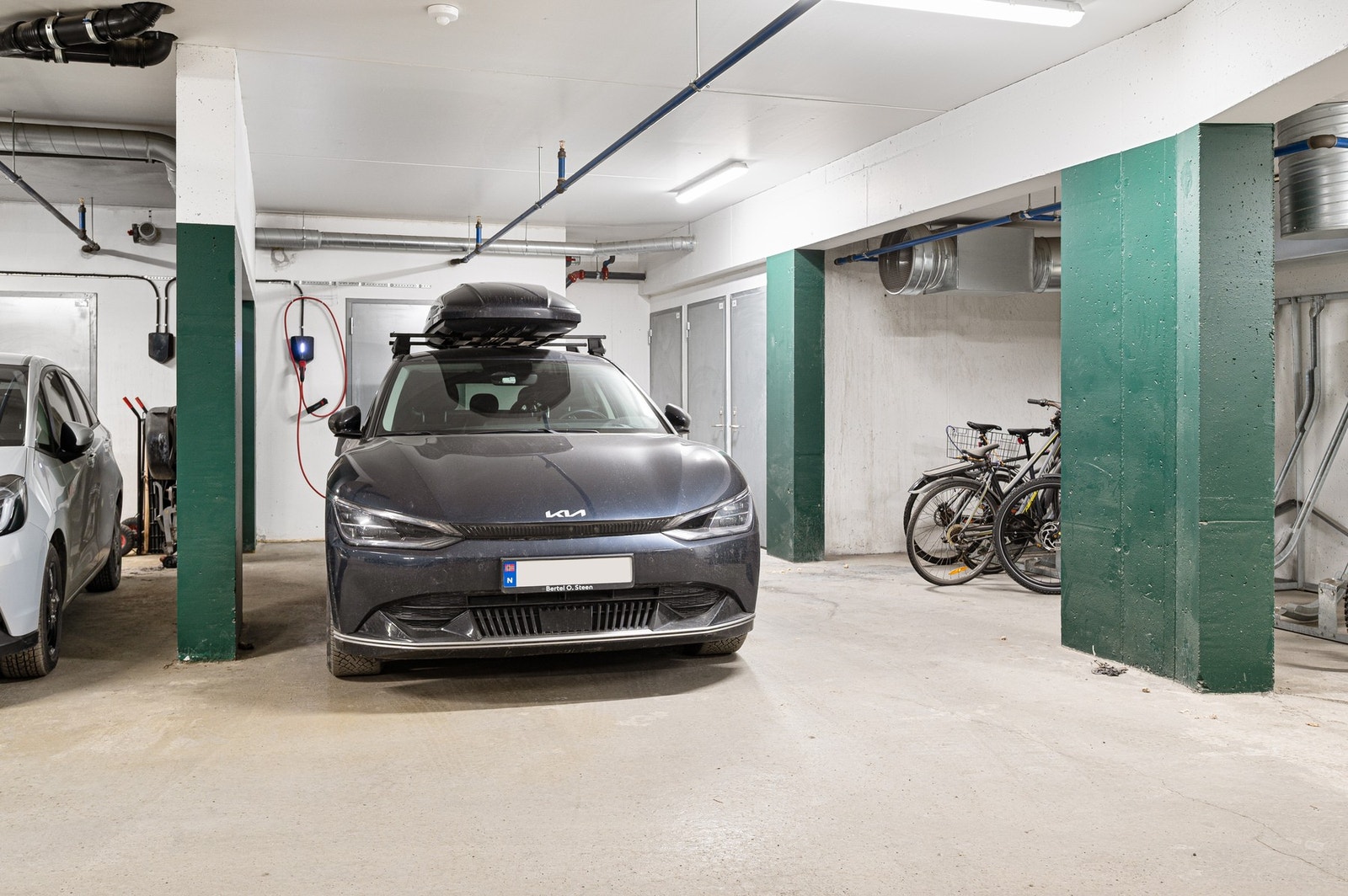 Parkeringsplass med elbillader i oppvarmet kjeller. Bod i bakkant. Galleribilde