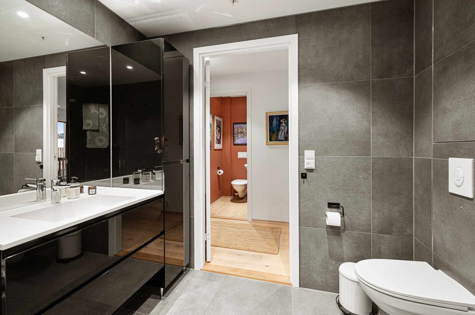 Baderommet har vegghengt toalett og servant med underskap og sideskap. Galleribilde