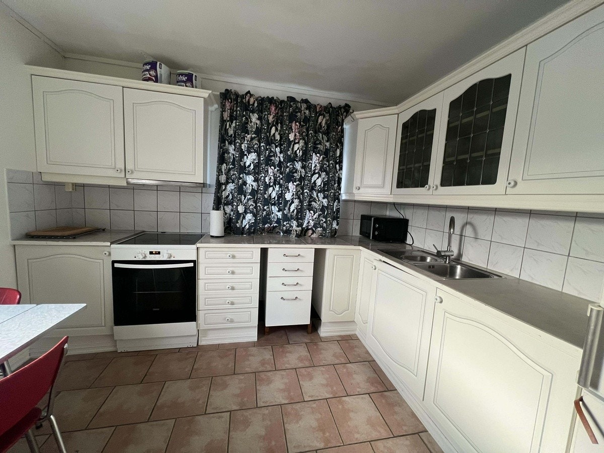 Kjøkken med fliser på gulvet, kombiskap kjø/frys og komfyr Galleribilde