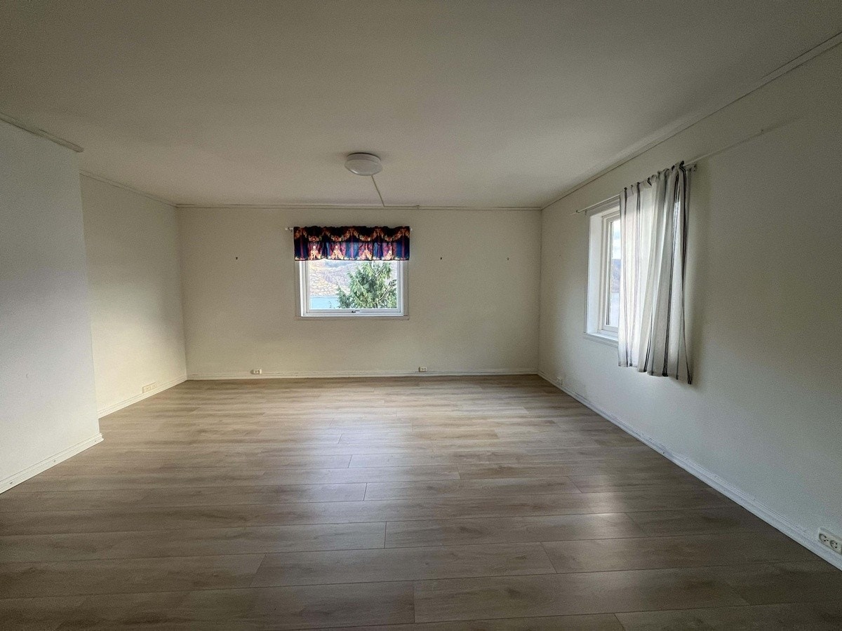 Stuen har flere vinduer som gir et naturlig lysinnslipp Galleribilde