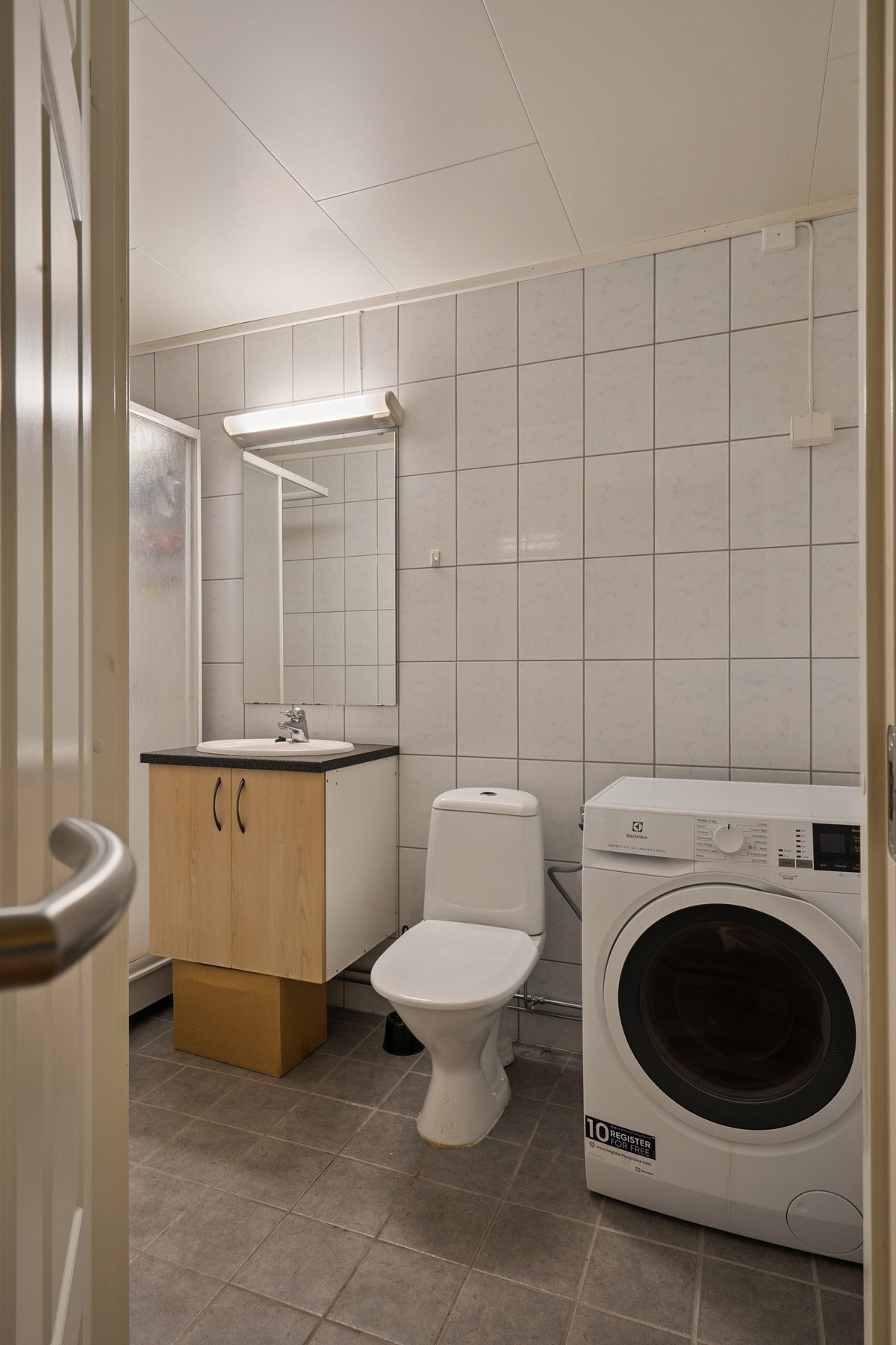 Badet er innredet med nedfelt servant, toalett, dusjkabinett og opplegg for vaskemaskin Galleribilde