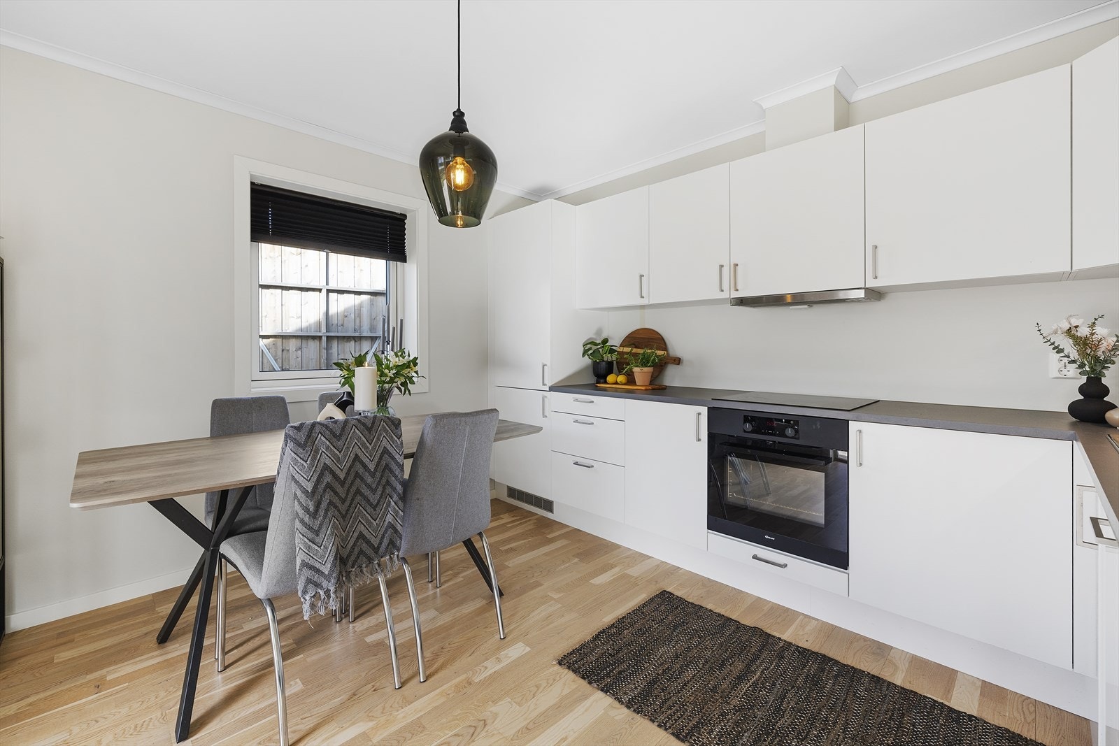 Kjøkkeninnredningen har integrerte hvitevarer som kjøleskap/fryseskap, oppvaskmaskin, stekeovn og platetopp Galleribilde