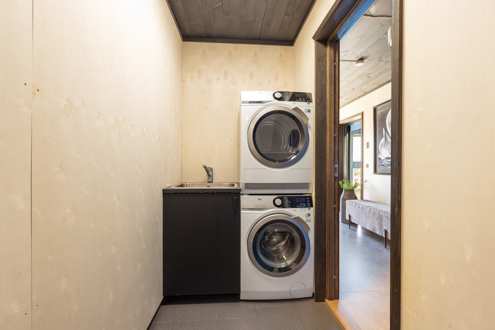 Praktisk vaskerom/teknisk rom med skap og nedfelt stålkum, samt opplegg for og plass til vaskemaskin og tørketrommel. Her er også ventilasjonsanlegg, el-tavle og varmtvannstank plassert. Galleribilde