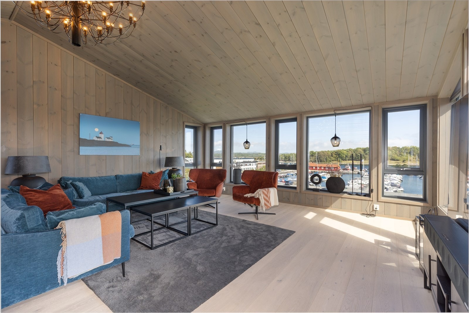 Hyggelig loftstue med vindusflater så å si fra gulv til tak som tar inn den nydelige utsikten mot båthavna og sjøen. Galleribilde