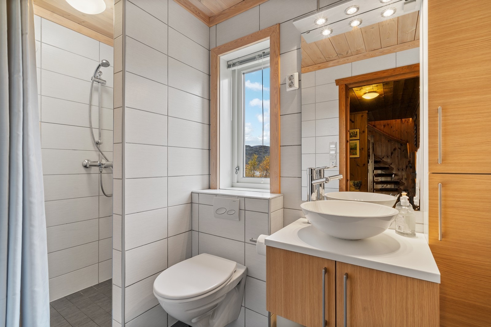 Lyst, flislagt bad med stilren innredning. Galleribilde