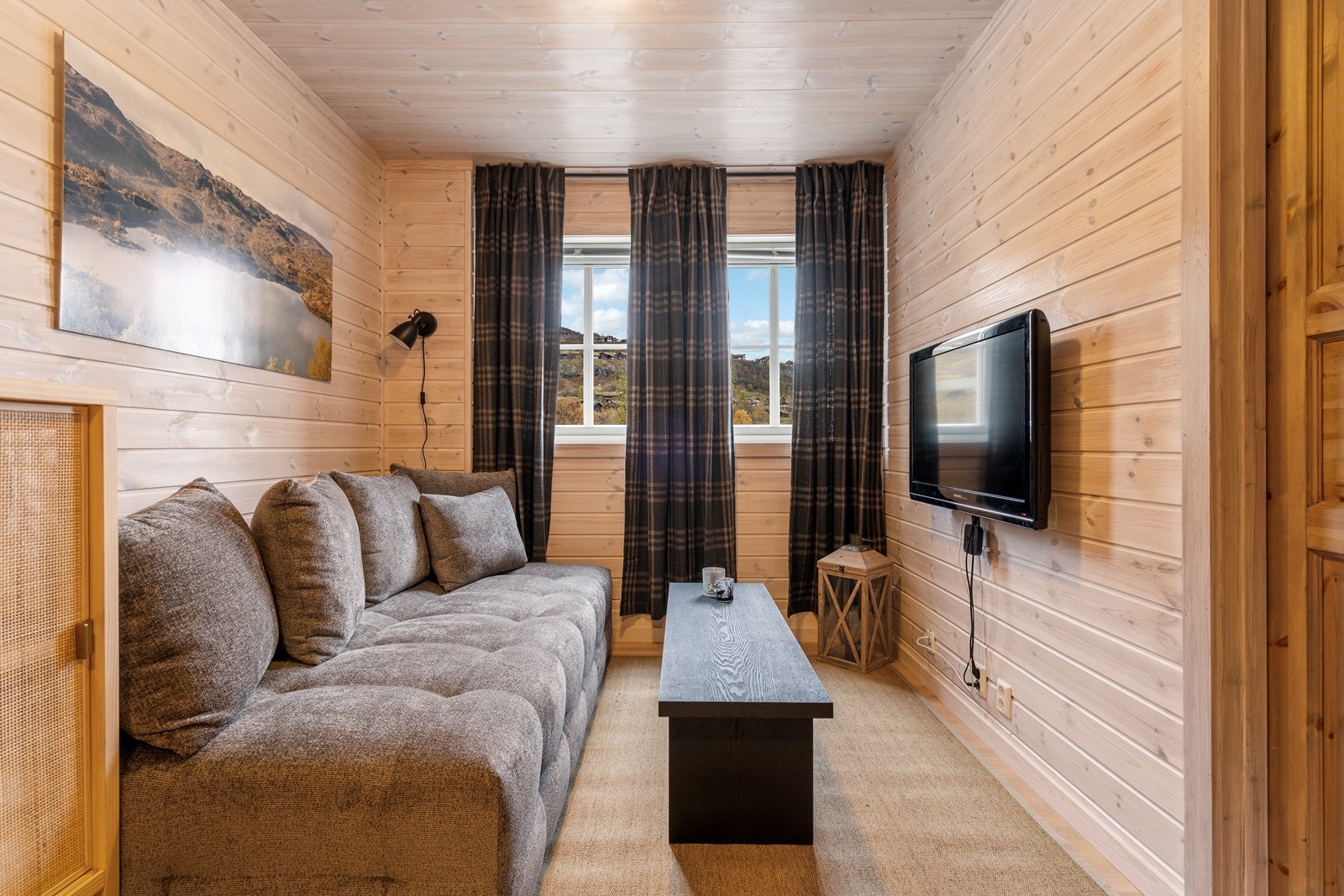 Lys og luftig kjellerstue med TV-krok i den ene enden - perfekt ekstra oppholdsrom. Galleribilde